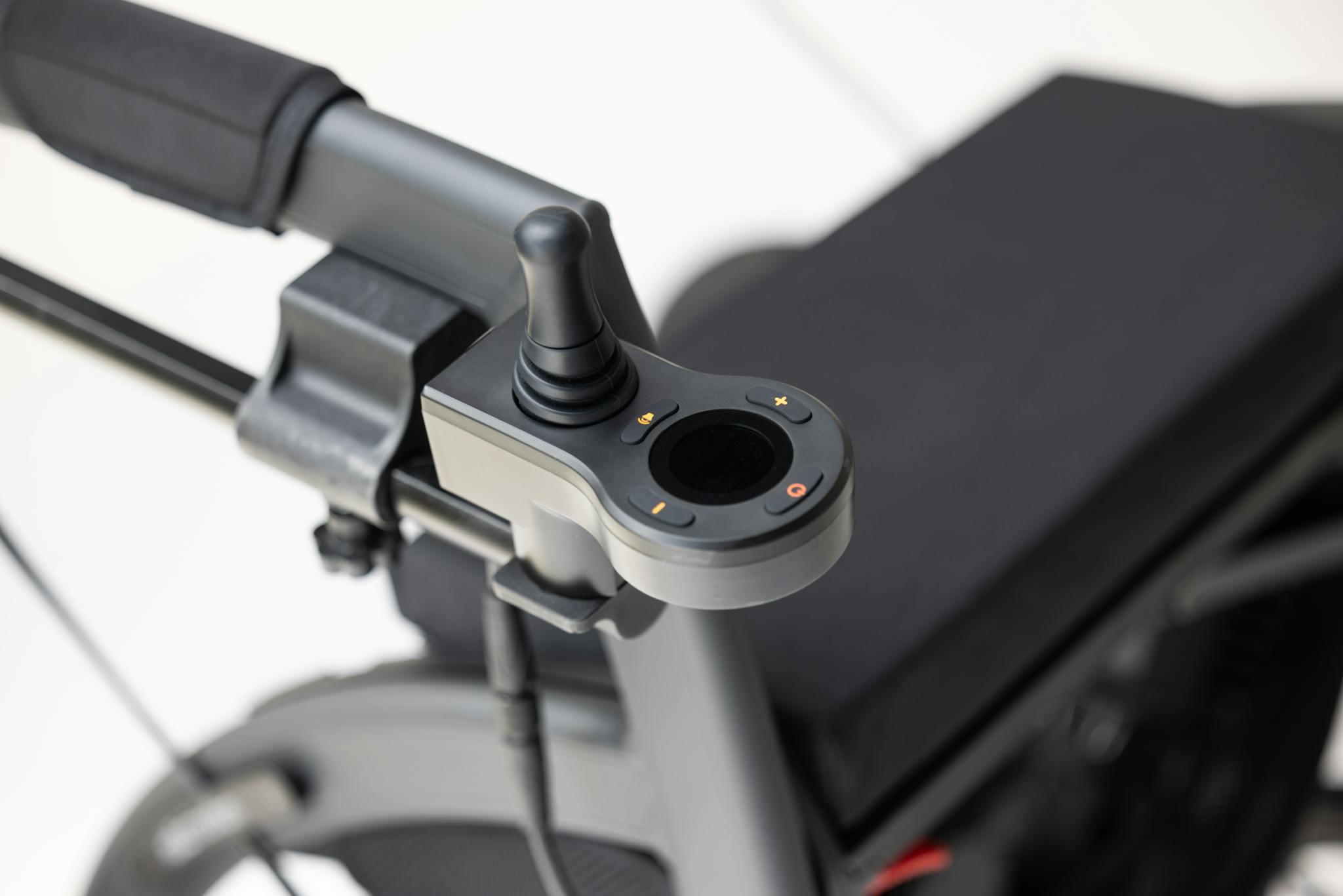 Close-up of an electric wheelchair joystick illustrating modern mobility technology.